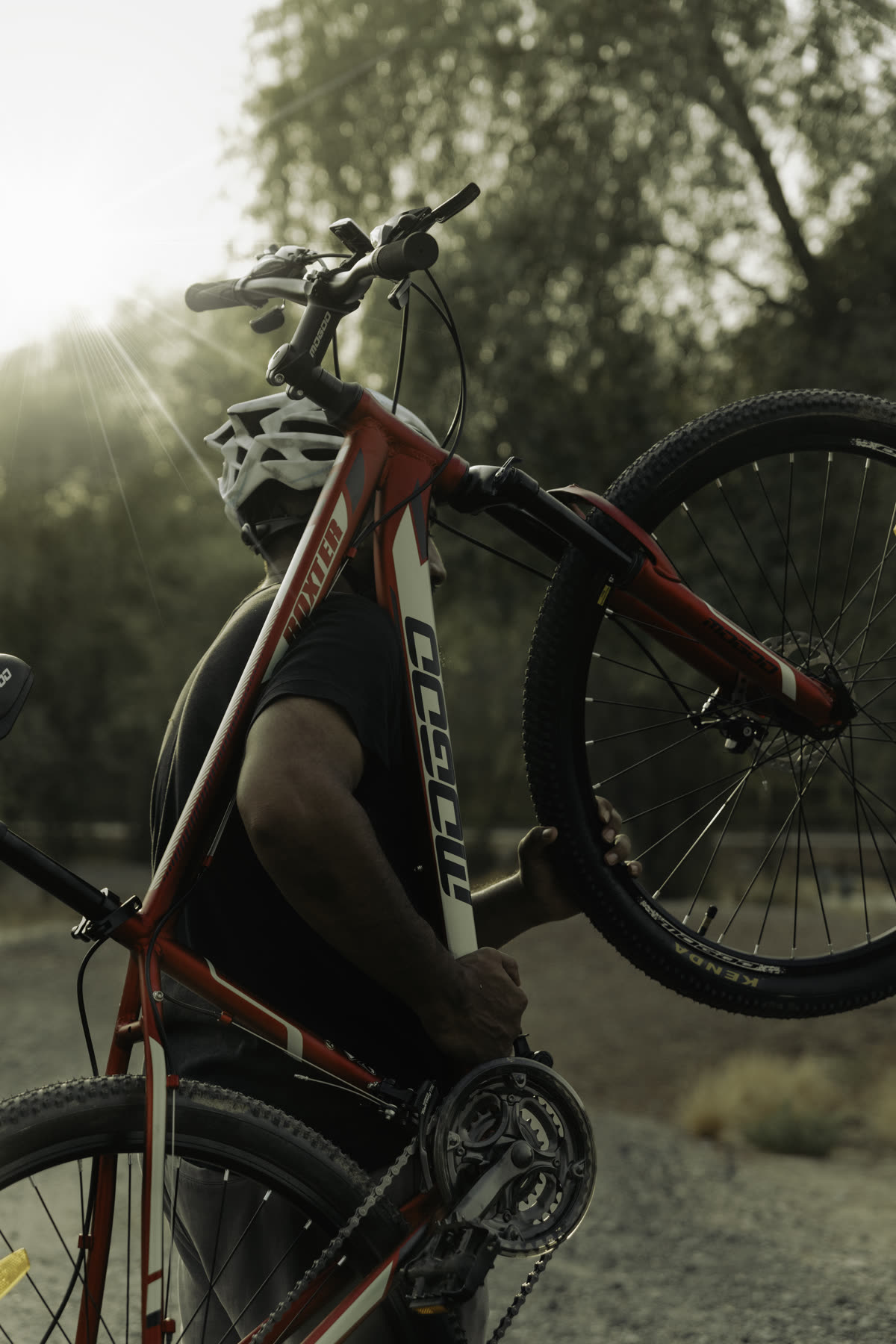 Lifestyle photography, cyclist carrying bike at golden hour