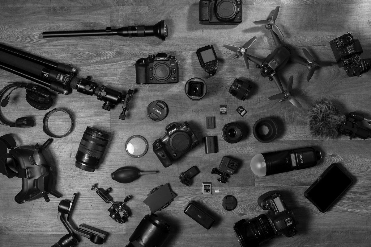 Camera bodies, lenses, drone and gimbal laid out on the studio floor