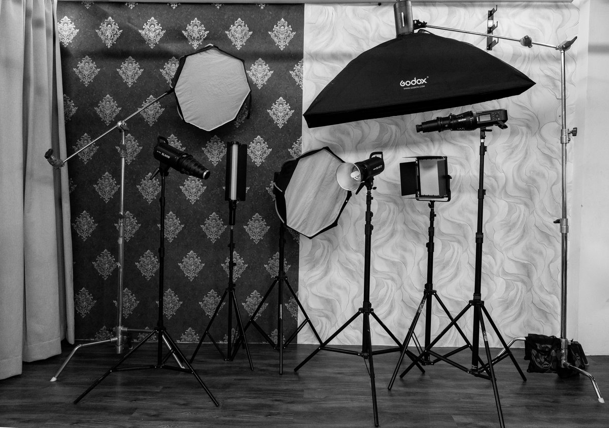 Softboxes, strobes and LED panels rigged against backdrop walls in the studio